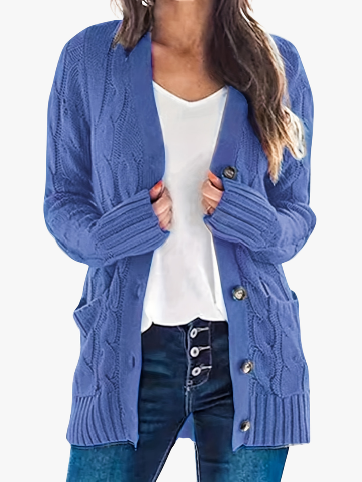 Delphine cable knit button front cardigan in blue, front view with hands in pockets