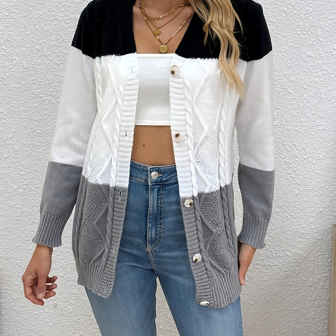 Delphine pink colorblock cable knit cardigan, front view holding coffee