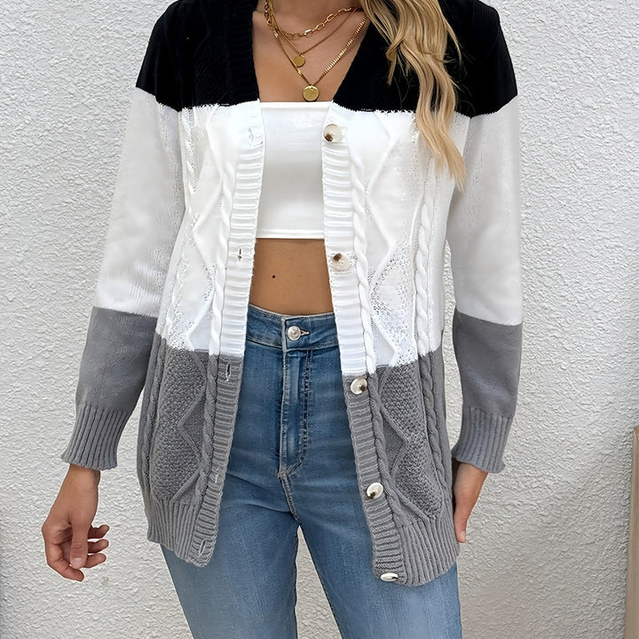 Delphine pink colorblock cable knit cardigan, front view holding coffee
