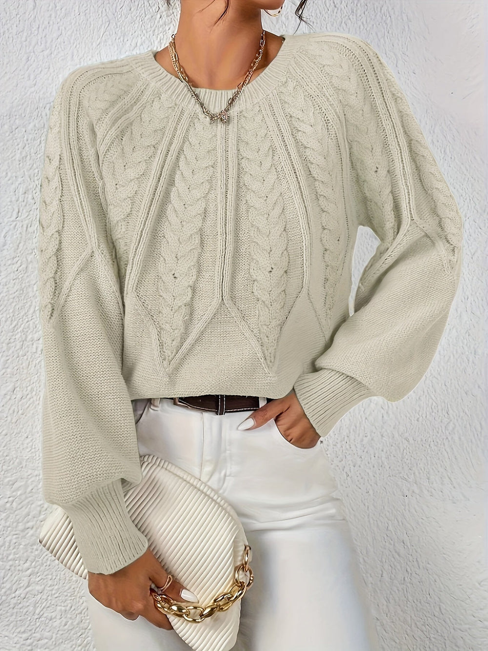 Elowen beige cable-knit round-neck sweater, front view with handbag