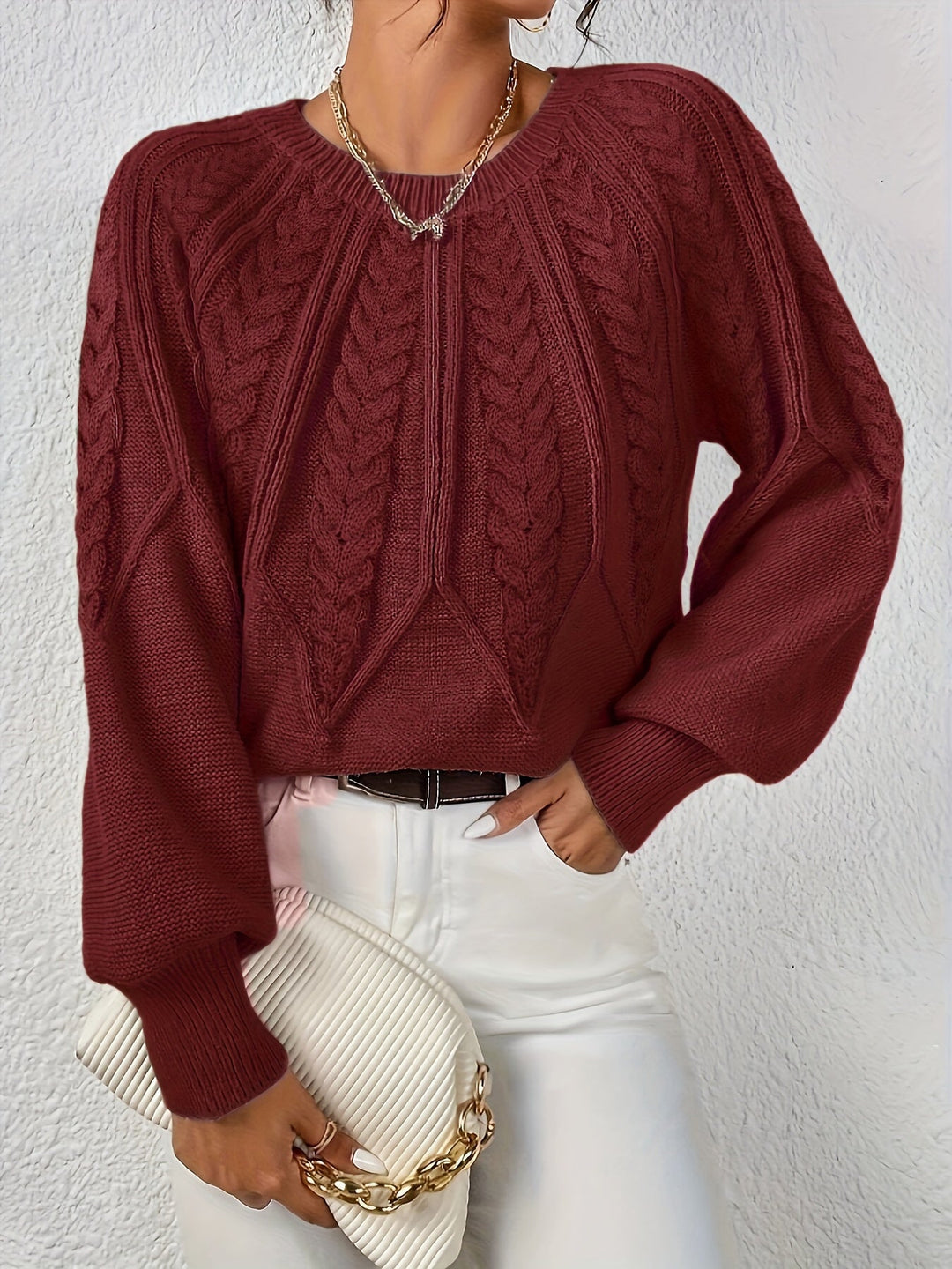 Elowen burgundy cable-knit round-neck sweater, front view with handbag
