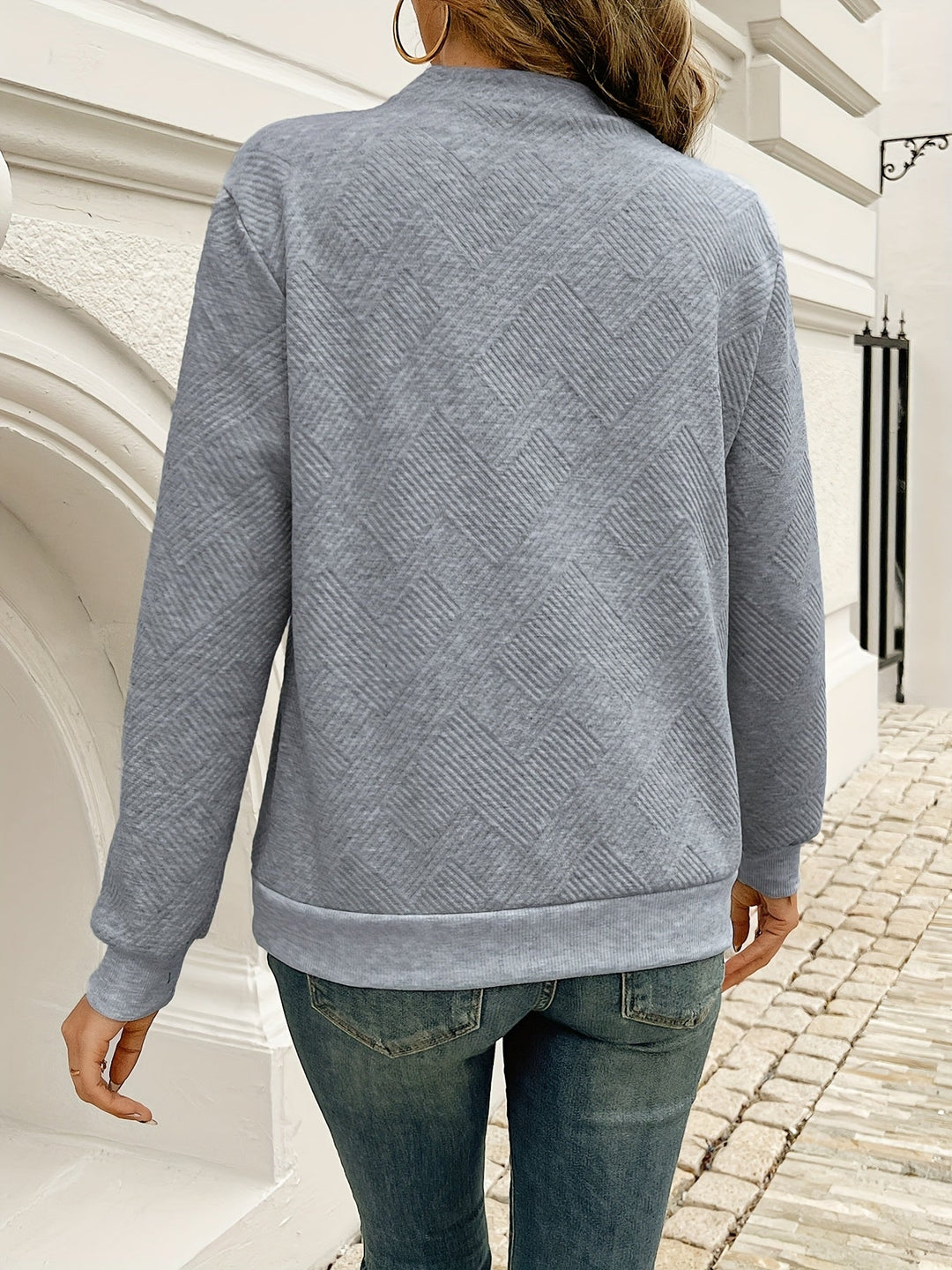 Everly asymmetrical button neck sweater, front view close hands